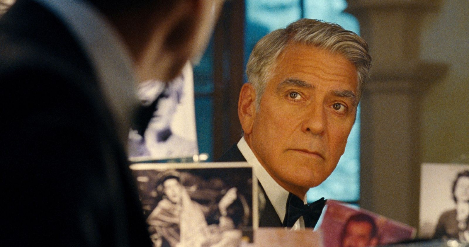 George Clooney blickt in einen Spiegel.