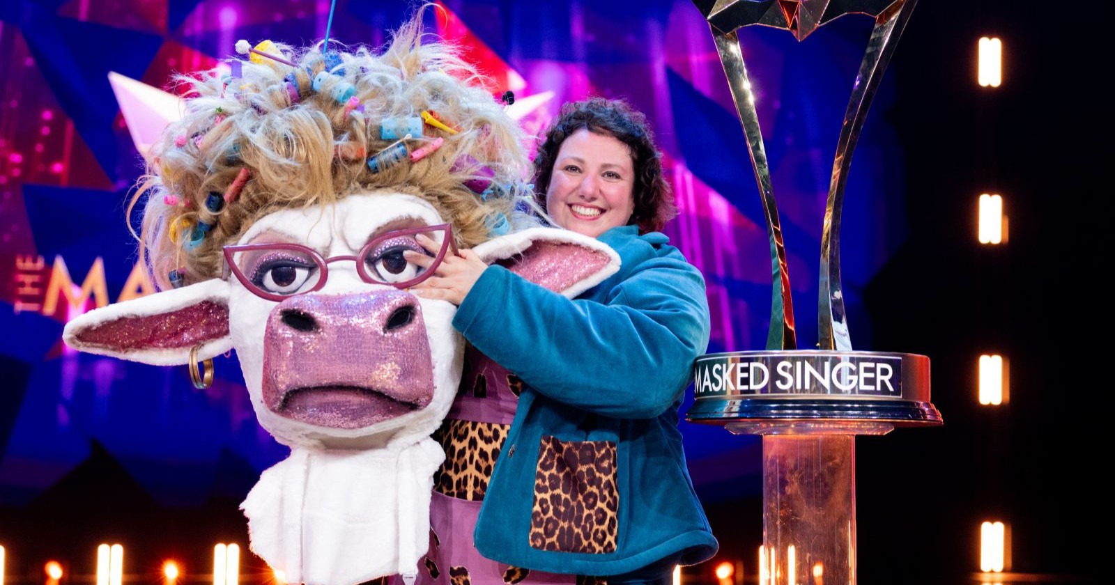 Eine Frau hält ein Kuh-Kostüm in der Hand.