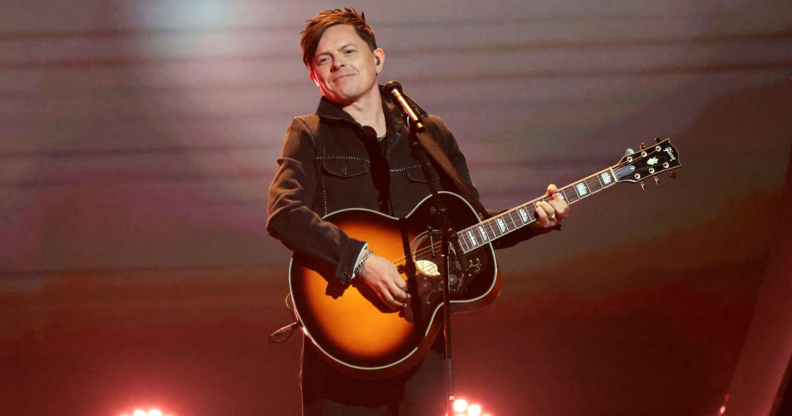 Ein Mann mit Gitarre steht auf der Bühne