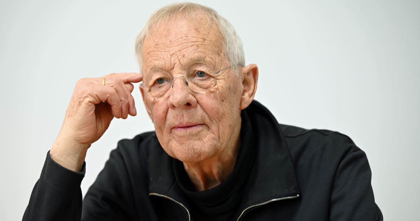 Ein alter Mann mit Brille greift sich an den Kopf