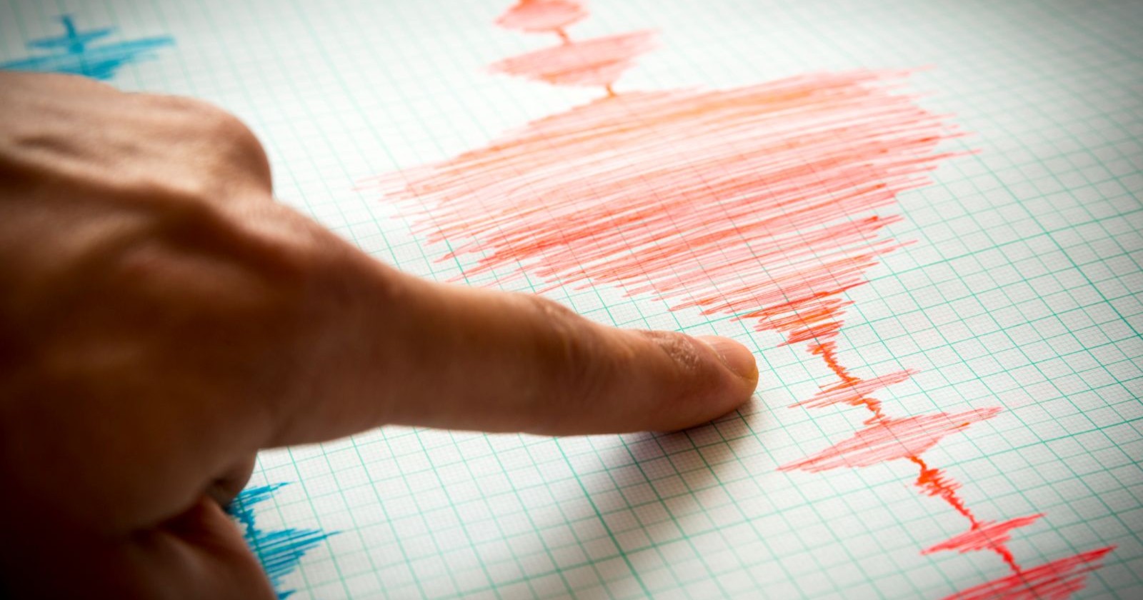 Ausgeschlagener Seismograph mit einem Finger der darauf zeigt
