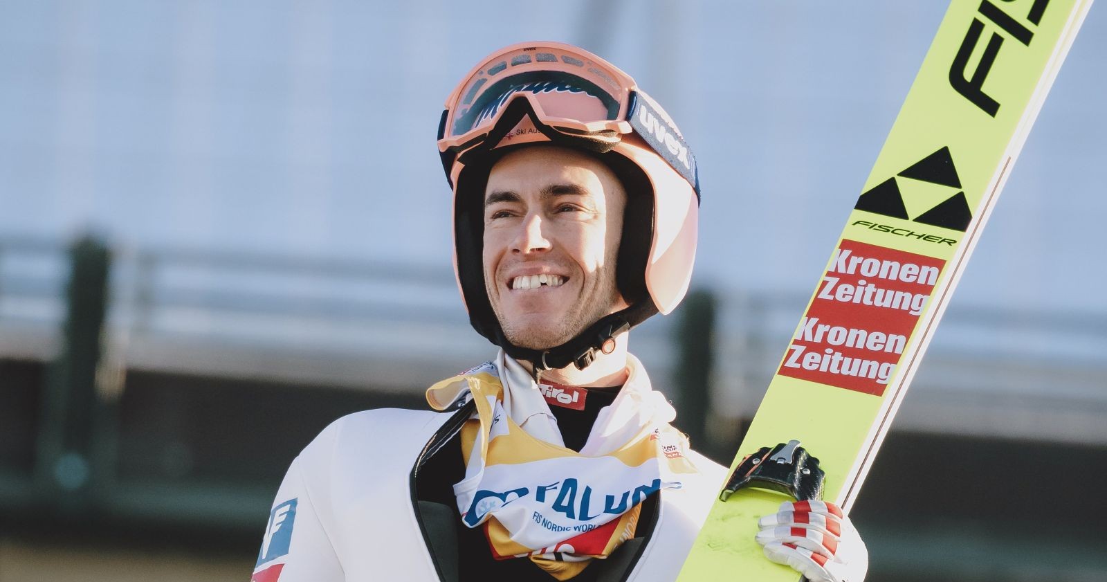 Skispringer Stefan Kraft mit Helm und Sprunganzug lächelt nach einem Wettkampf – Weltcup-Comeback kurz nach der Geburt seiner Tochter.