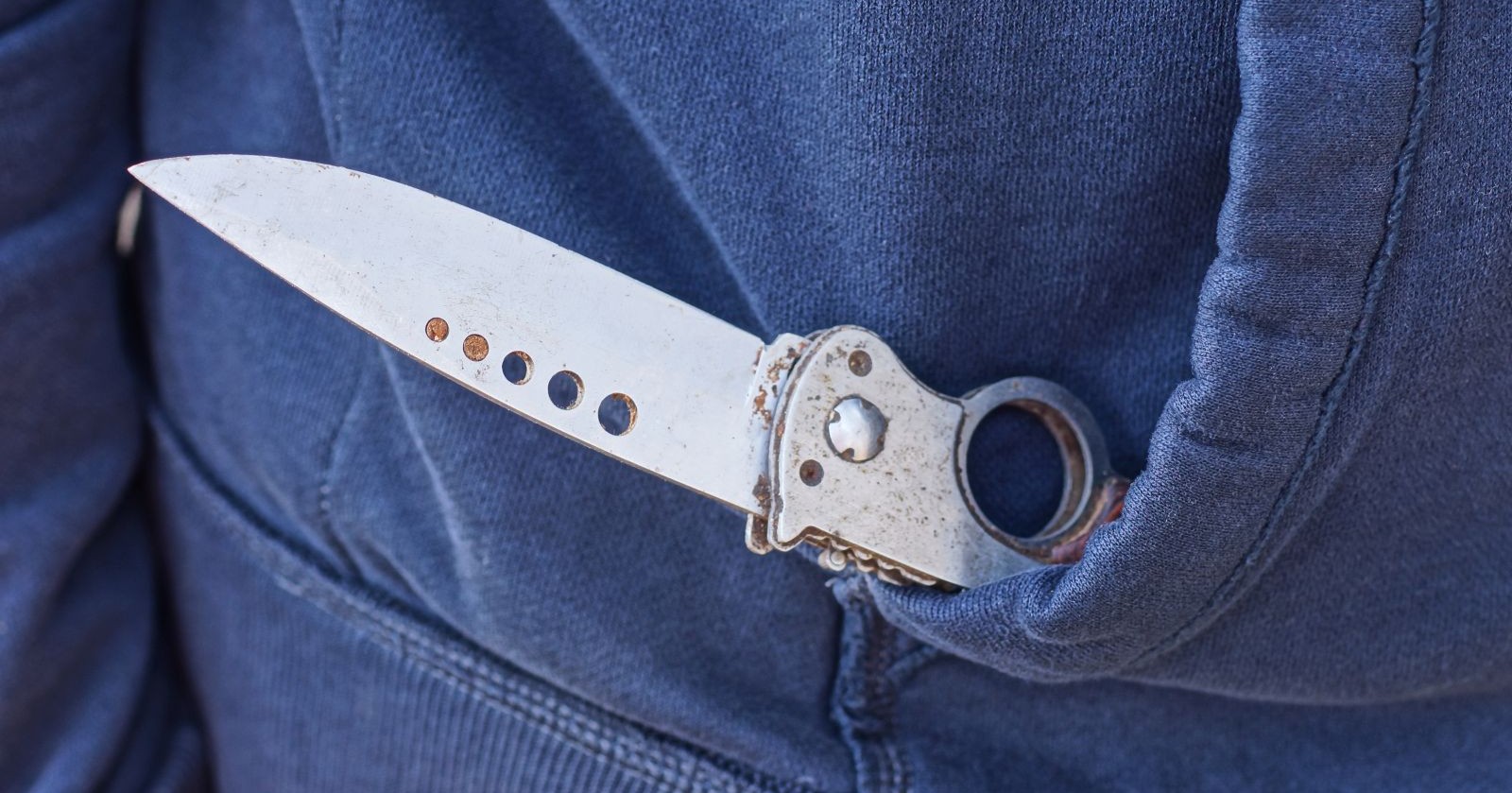 Klappmesser in blauem Kapuzenpulli