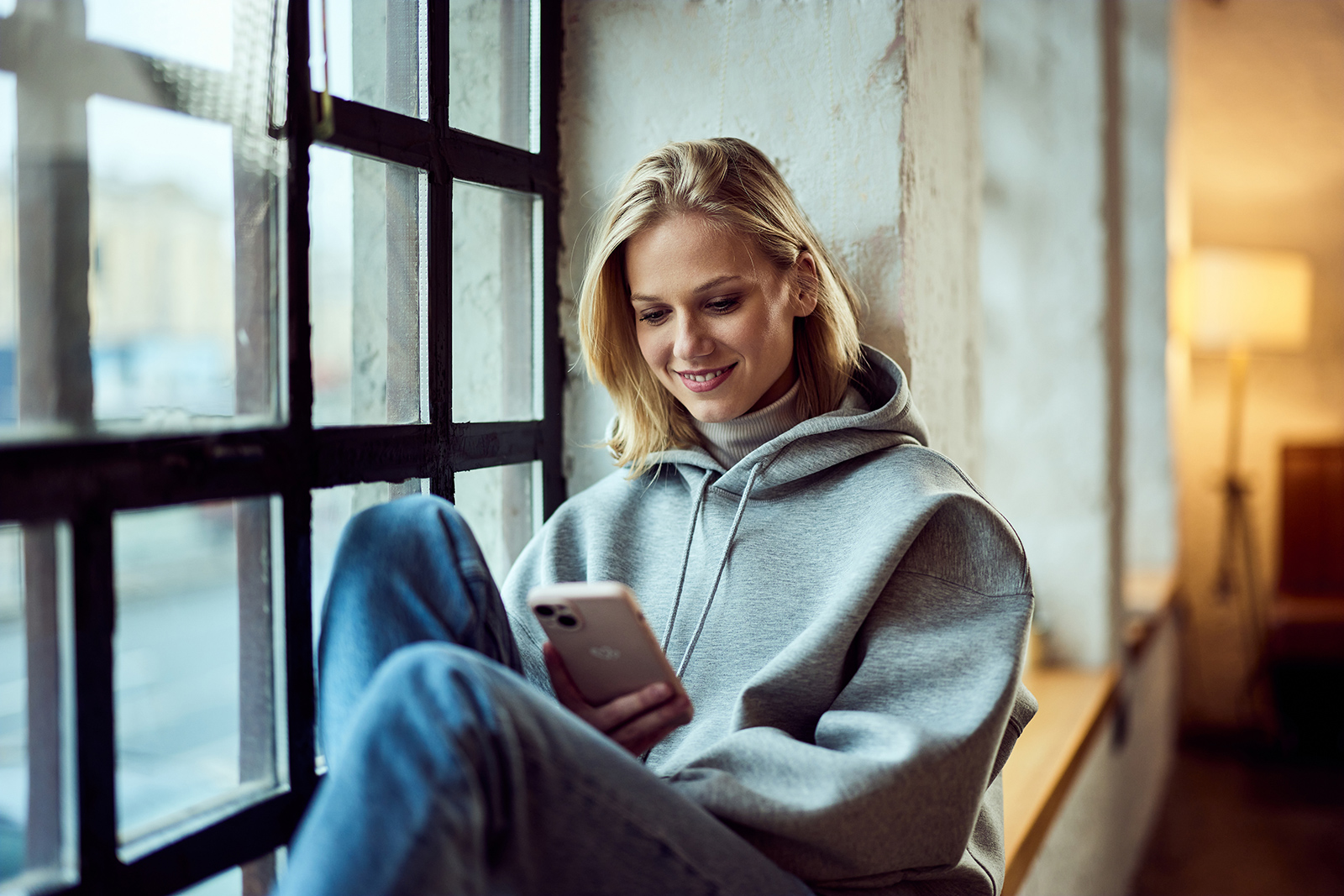 Junge Frau in Hoodie und Jeans | Credit: iStock.com/nortonrsx