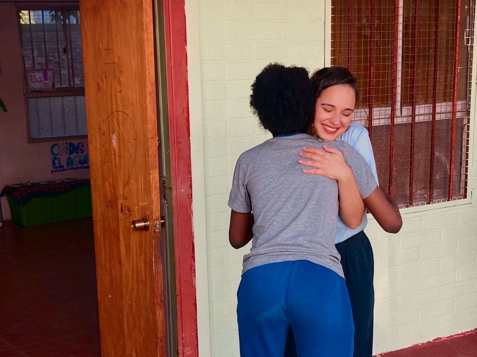 Die Sängerin Neiyla umarmt im Zuge ihrer Chile-Reise eine junge Frau | Credit: Kindernothilfe Österreich