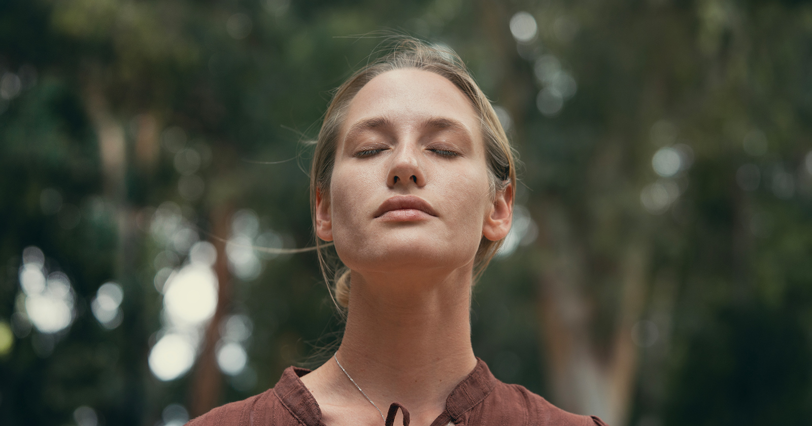 Junge Frau mit geschlossenen Augen im Wald | Credit: iStock.com/seb_ra