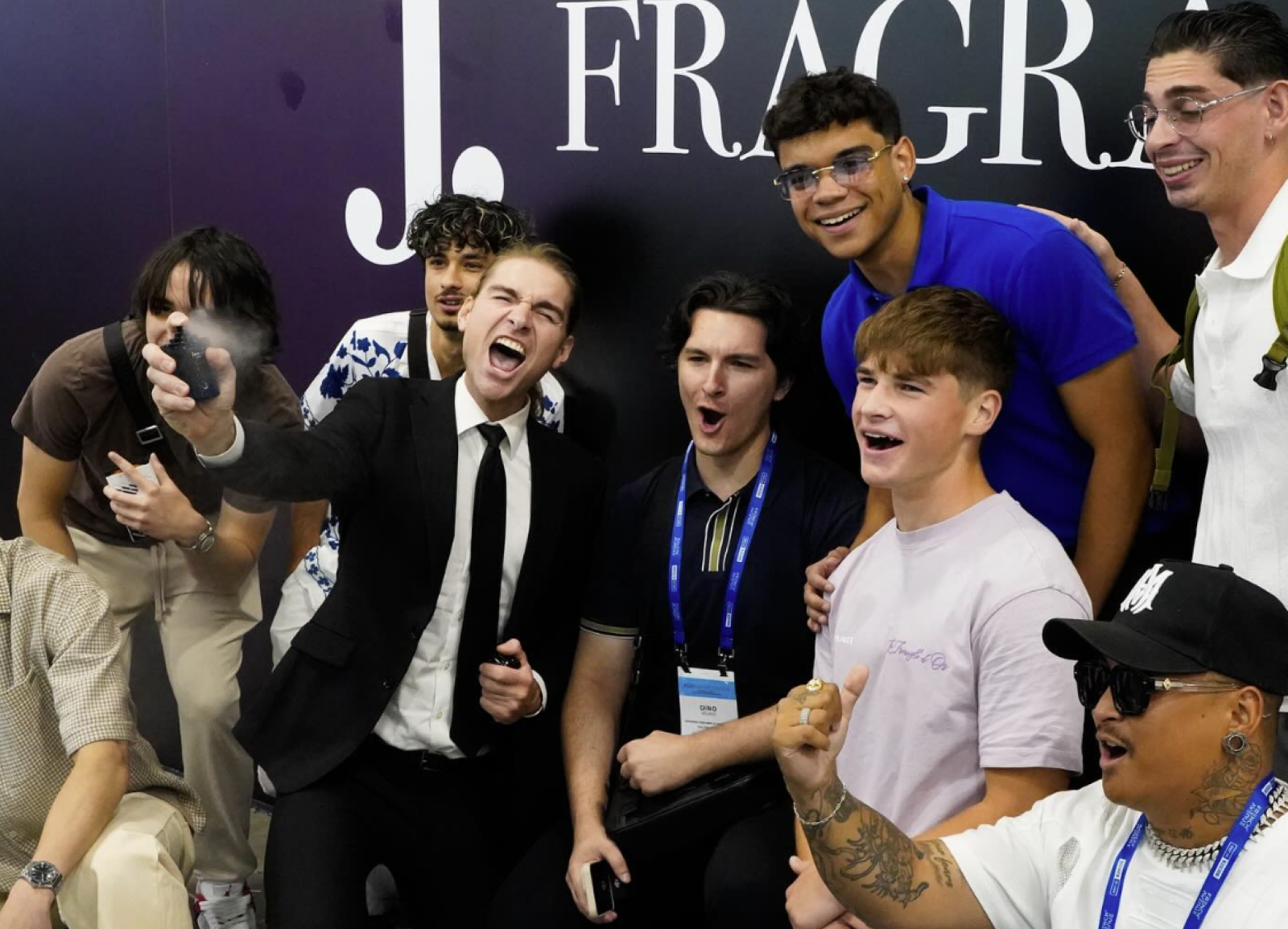 Gruppenbild, er in der Mitte mit einem Flakon sprühend