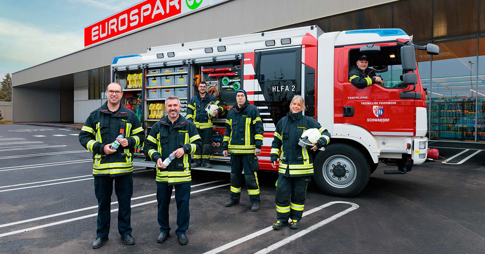 Mitglieder einer regionalen Feuerwehr vor eine SPAR-Supermarkt