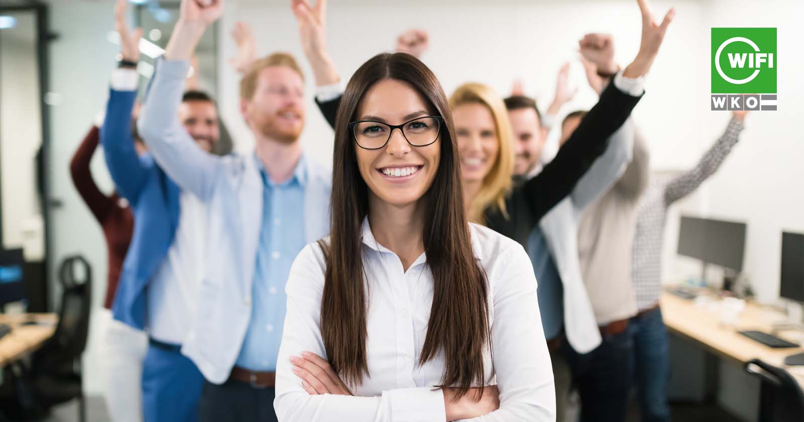 Junge Frau vor ihren jubelnden Kolleginnen und Kollegen | Credit: WIFI OÖ