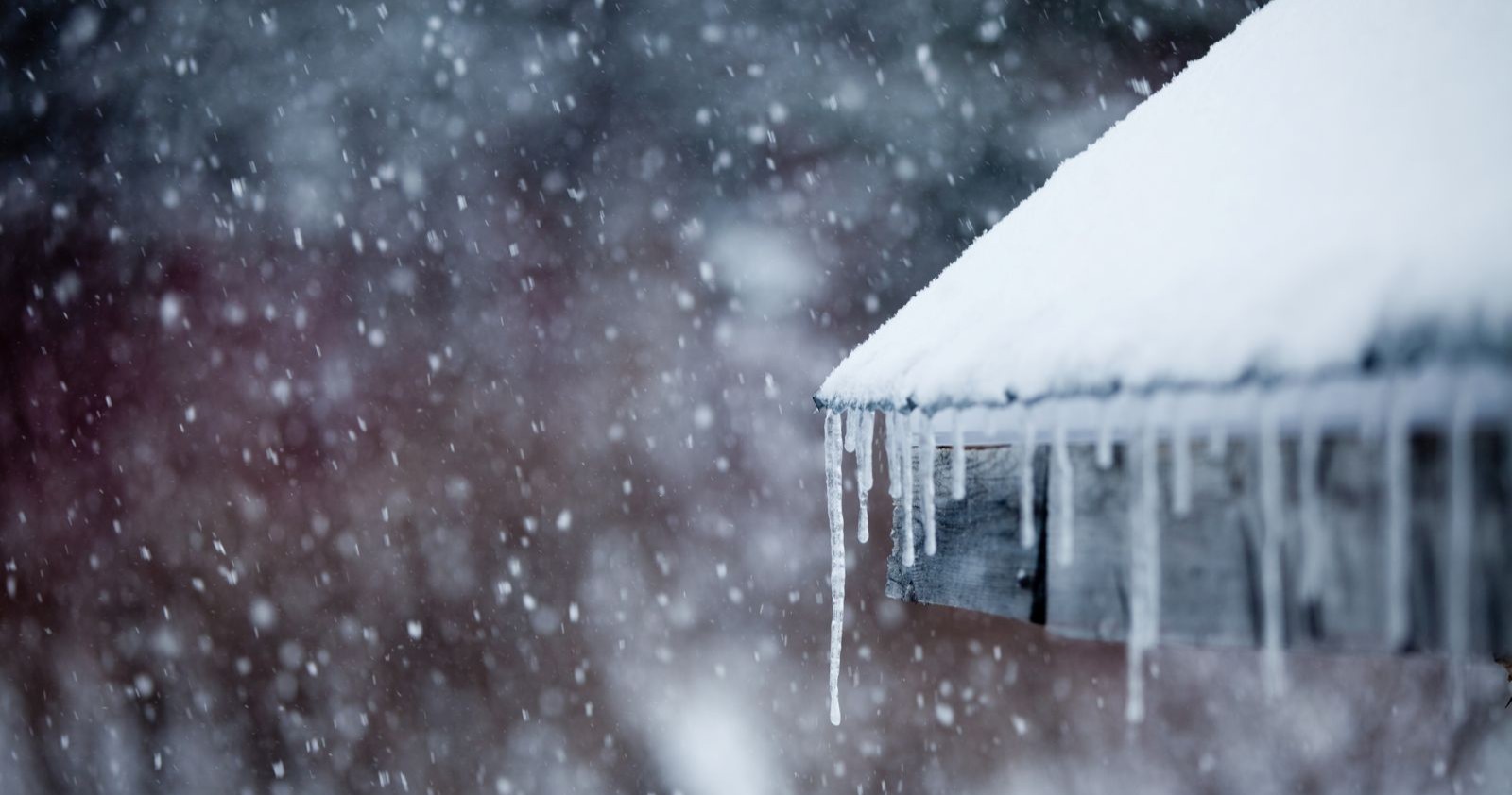 Eiszapfen an einem verschneiten Dach.