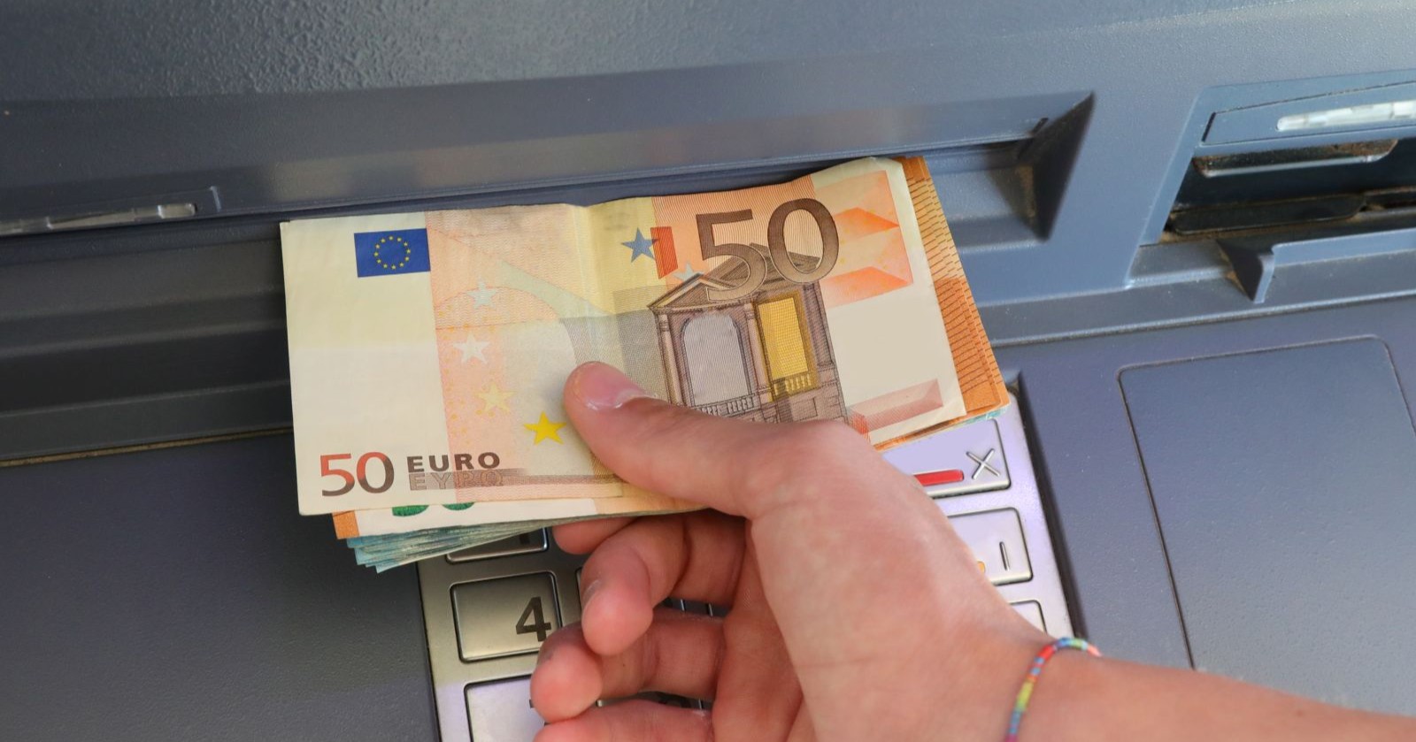 Eine Hand die Geld abhebt.