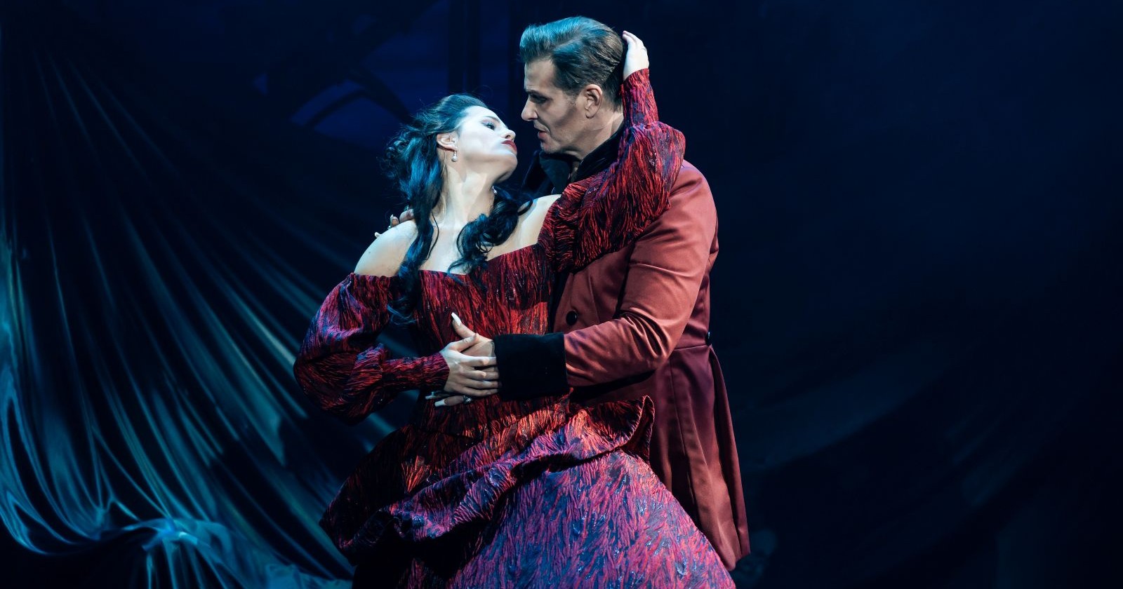 Dracula-Darsteller Jan Ammann im roten Gehrock hält Mina-Darstellerin Lisa Habermann im roten Kleid