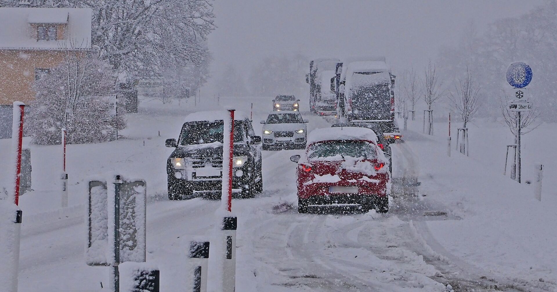 Autos auf einer verschneiten Fahrbahn.