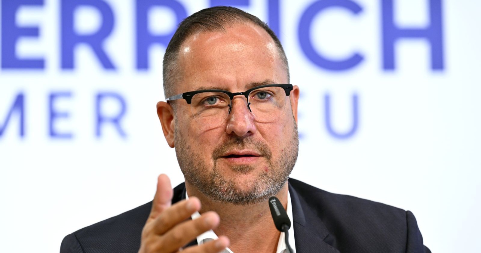 Christian Hafenecker spricht bei einer Pressekonferenz vor Mikrofonen – er verteidigt FPÖ-Chef Herbert Kickl und kritisiert ORF-Moderator Armin Wolf.