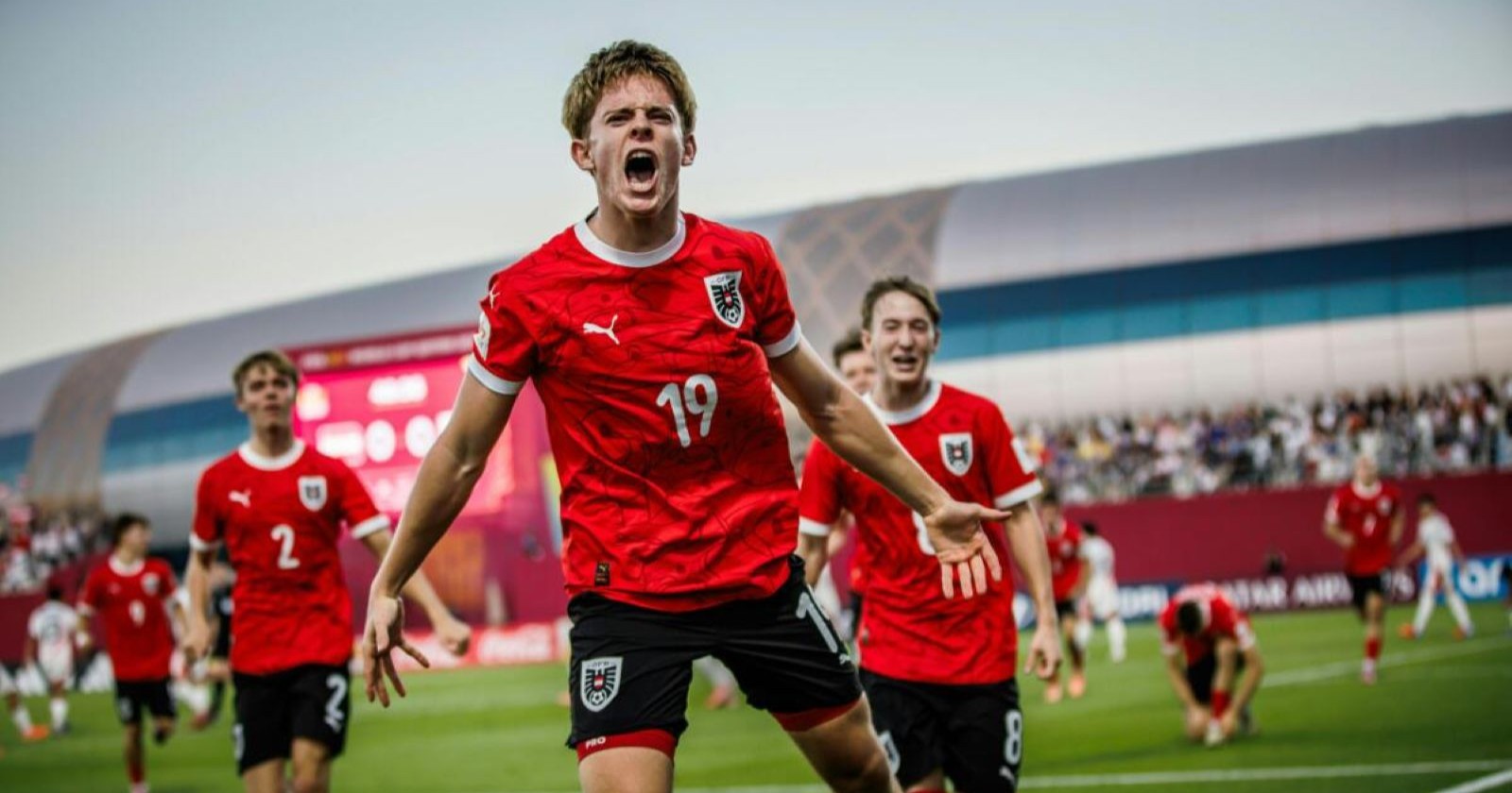 Johannes Moser im roten Trikot jubelt lautstark über ein Tor, im Hintergrund feiern seine Teamkollegen während des Halbfinales gegen Italien.