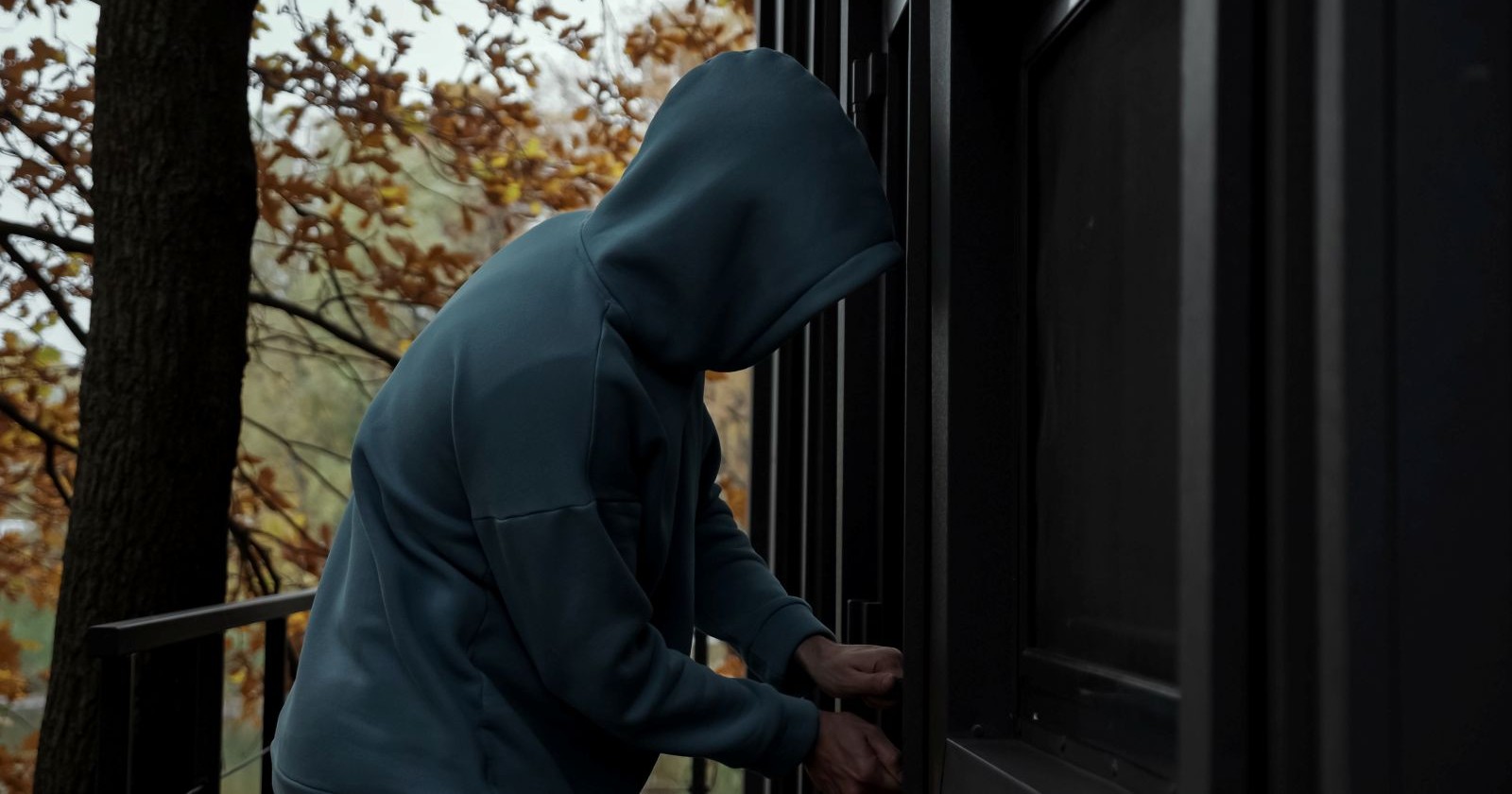 Mann mit Kapuze vor Haustüre