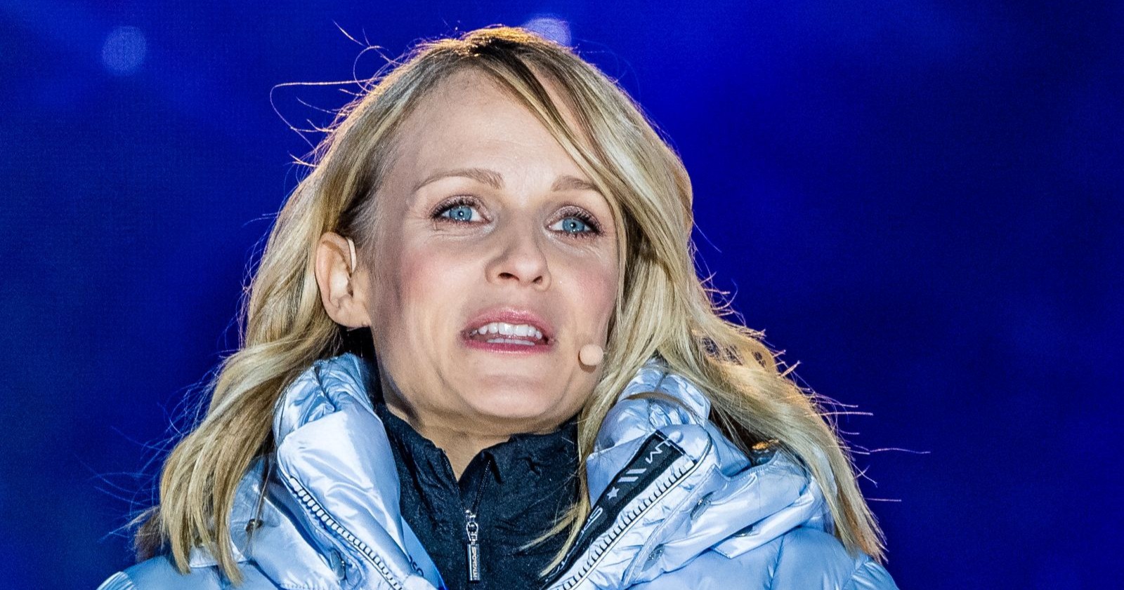 Mirjam Weichselbraun in warmer Winterjacke auf einer Bühne, spricht ins Mikrofon – sie sorgt mit einem ungewöhnlichen Expeditions-Geschenk für Aufsehen.