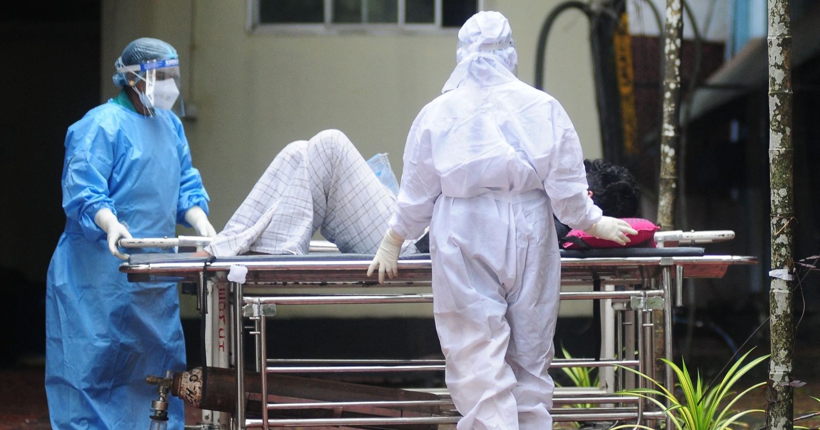 Nipah Virus Indien: Schutzkleidung tragende Gesundheitskräfte transportieren einen Patienten während eines Nipah-Virus-Ausbruchs in einem indischen Krankenhaus.