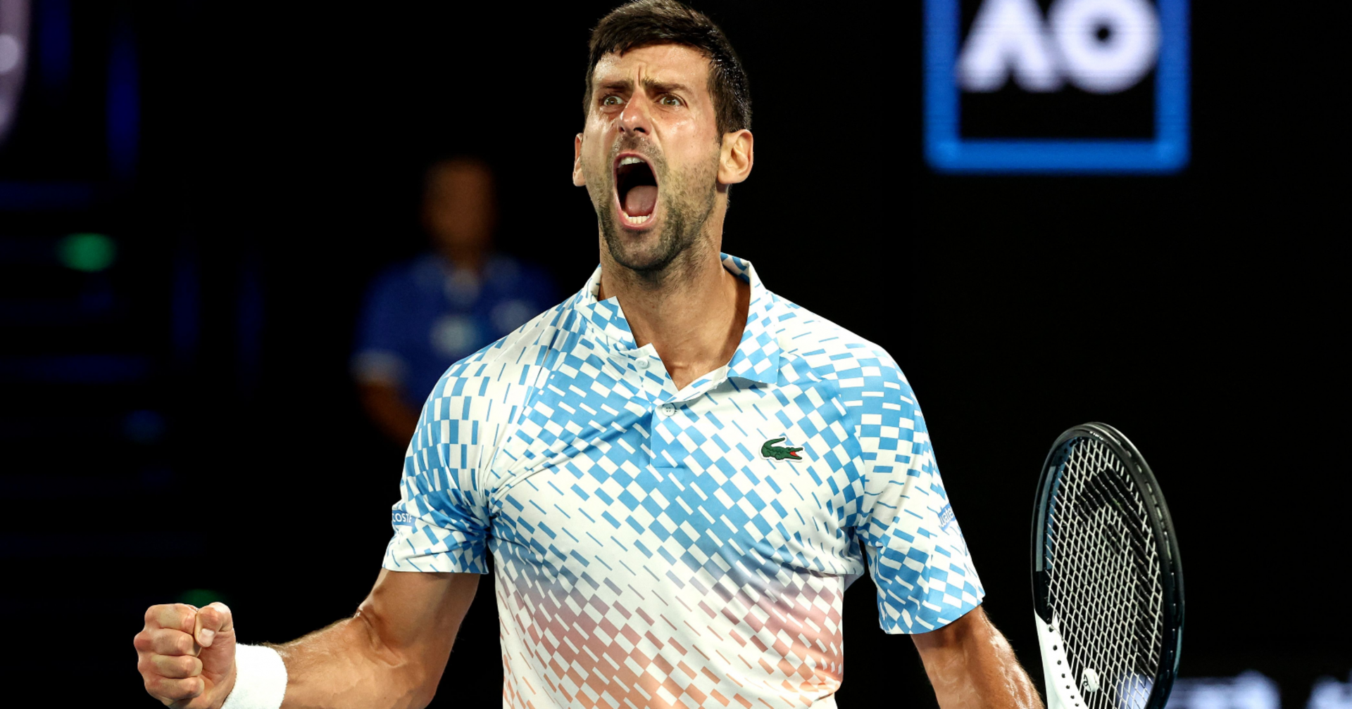 Der auf dem Tennisplatz jubelnde Novak Djokovic, der ein weißes Tennisdress mit einem blauen Karomuster trägt