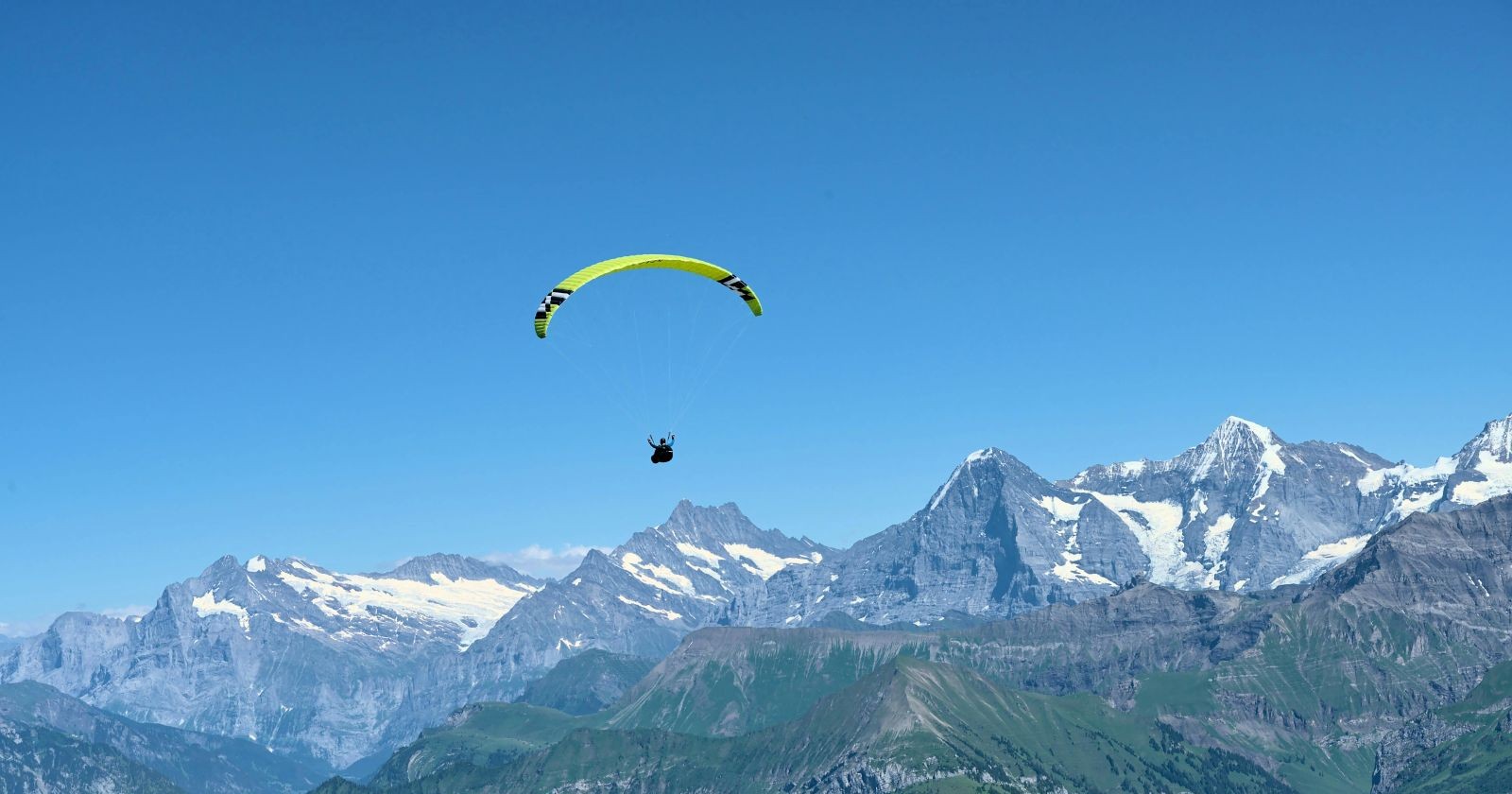Paragleiter fliegt über Gebirge