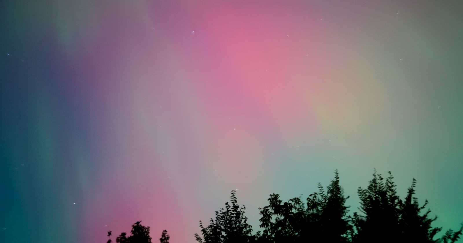 Polarlichter Österreich – rotes und grünes Himmelsleuchten über den Alpen bei klarem Nachthimmel.