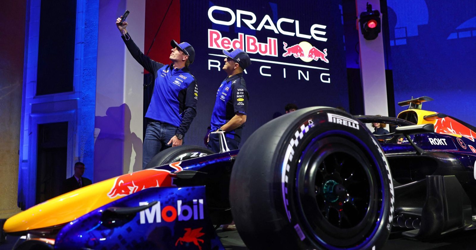 Zwei Red-Bull-Racing-Fahrer stehen neben dem neuen Formel-1-Auto und machen ein Selfie bei der Präsentation der 2026-Lackierung in Detroit; im Hintergrund ist das Oracle-Red-Bull-Racing-Logo zu sehen.