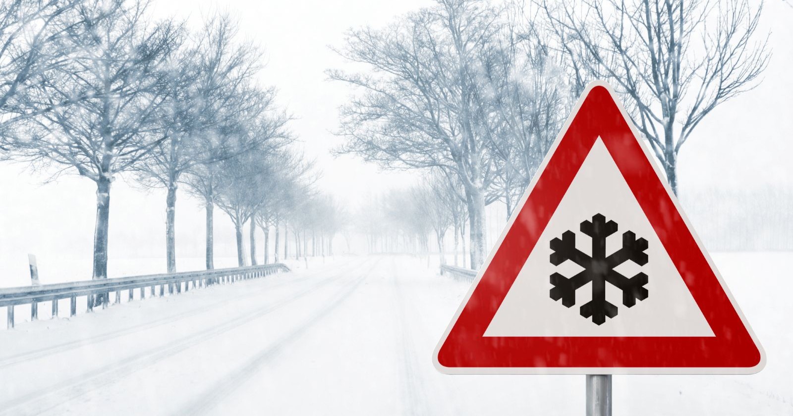 Schneefallgrenze Wetter in Österreich – winterliche Straße mit Schneeflocken-Warnschild, Hinweis auf Glätte und winterliche Fahrbedingungen.