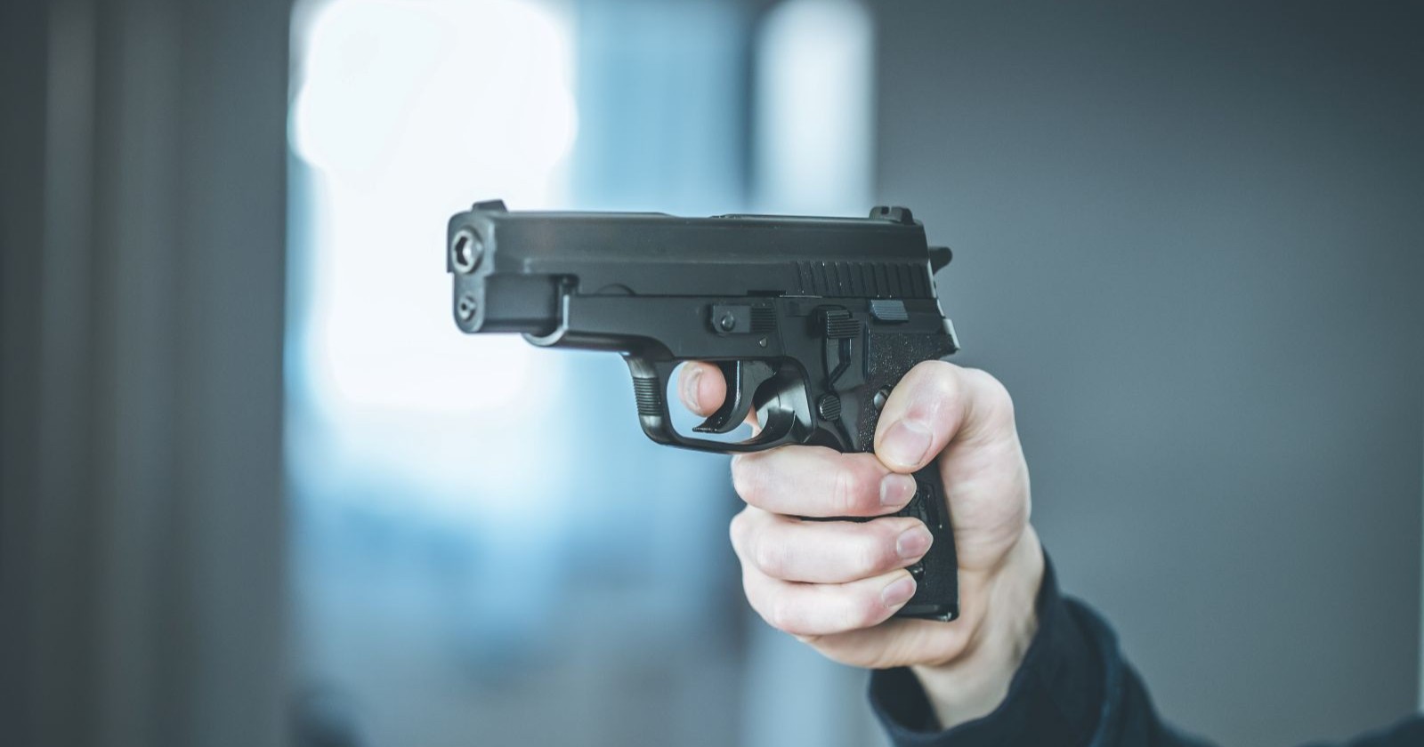 Hand mit schwarzer Pistole