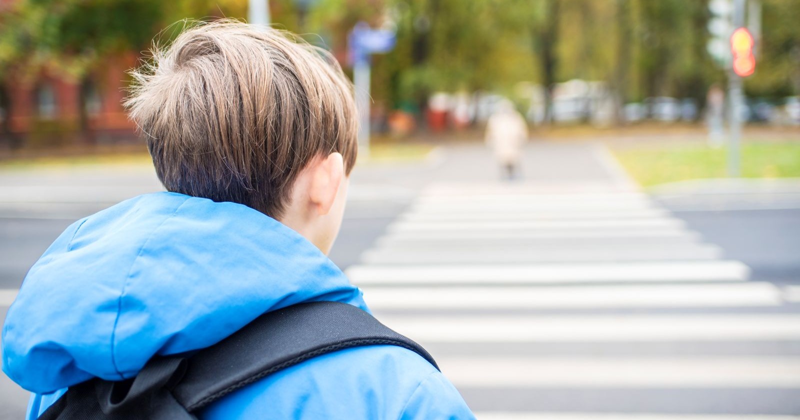Bub mit blauer Jacke auf Straße