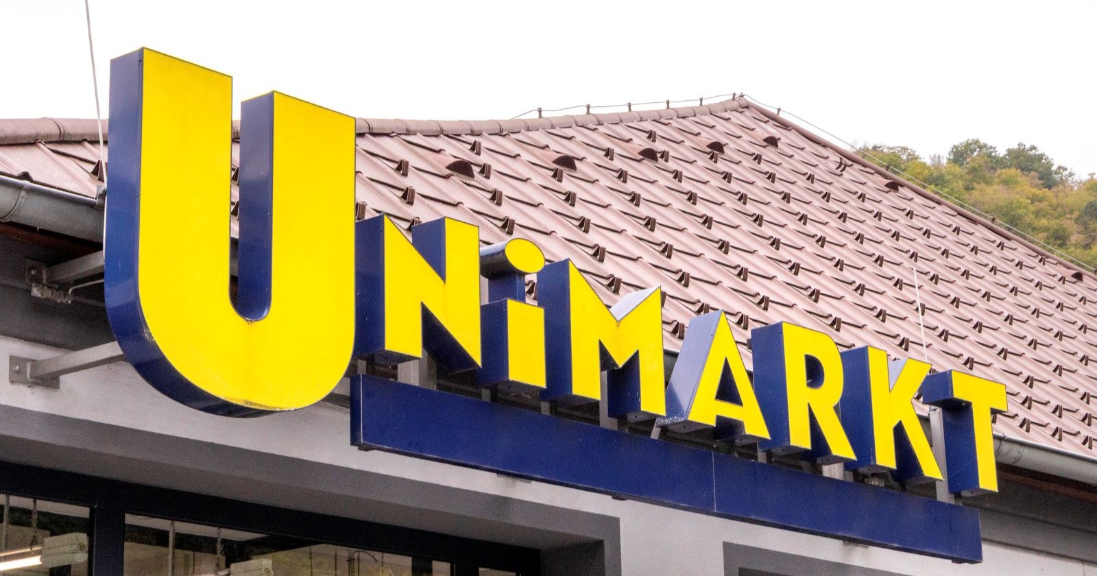 Unimarkt-Filiale mit gelb-blauem Logo – Spar übernimmt 23 Unimarkt Filialen in Österreich, zwei davon in Salzburg, im Rahmen der BWB-genehmigten Übernahme.