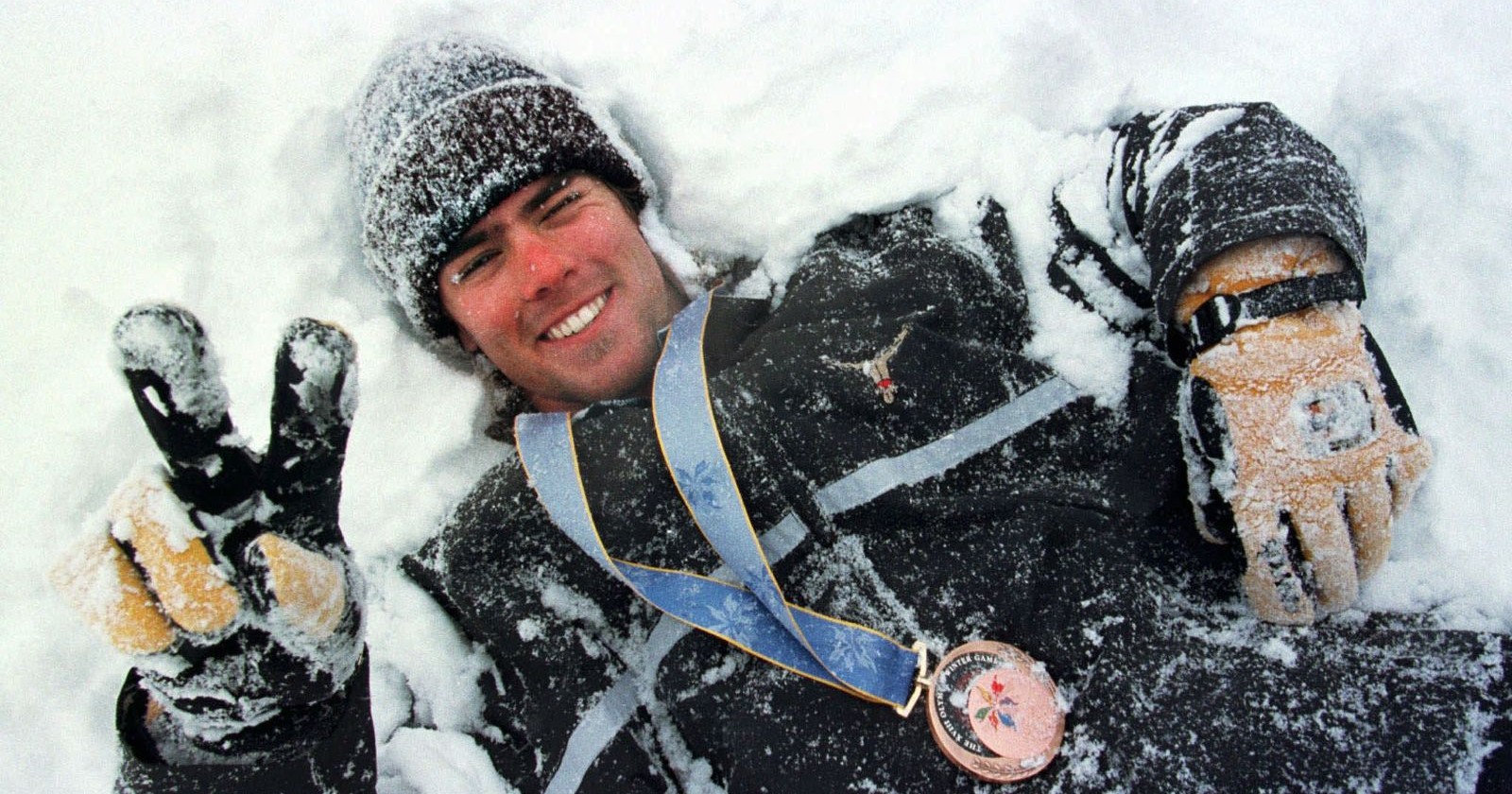 Der Schweizer Snowboarder Ueli Kestenholz wälzt sich am Montag, 9. Februar 1998, im Schnee von Shiga Kogen, geschmueckt mit der Bronzemedaille, die er am Vortag am olympischen Snowboard-Riesenslalom gewonnen hat.
