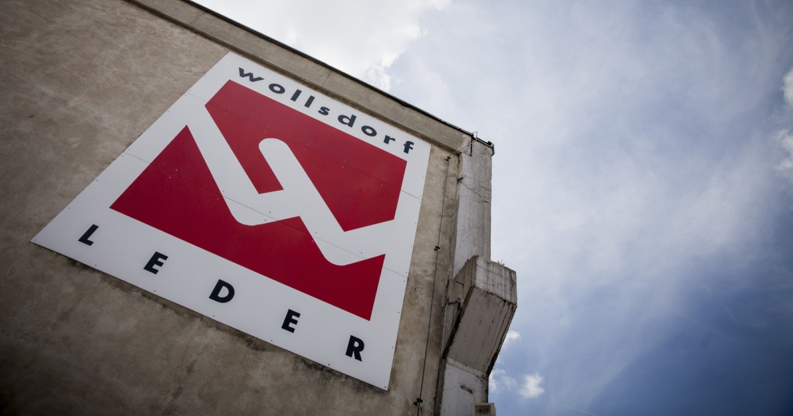 Das Logo von Wollsdorf Leder abgebildet auf dem Bürogebäude.