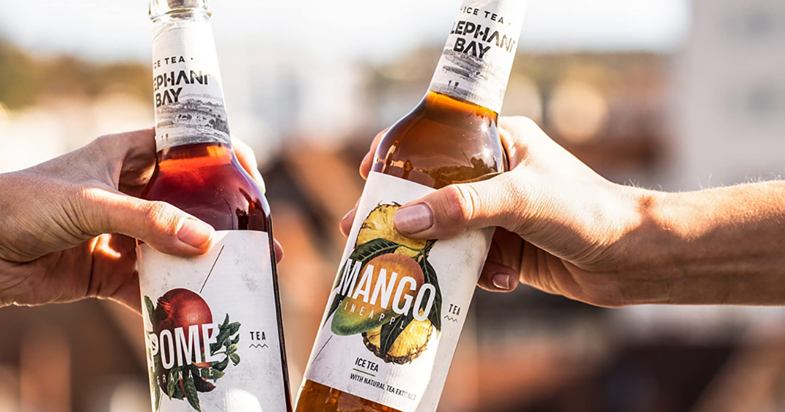 Zwei Menschen prosten sich mit Flaschen zu | Credit: premium-drinks &amp; more