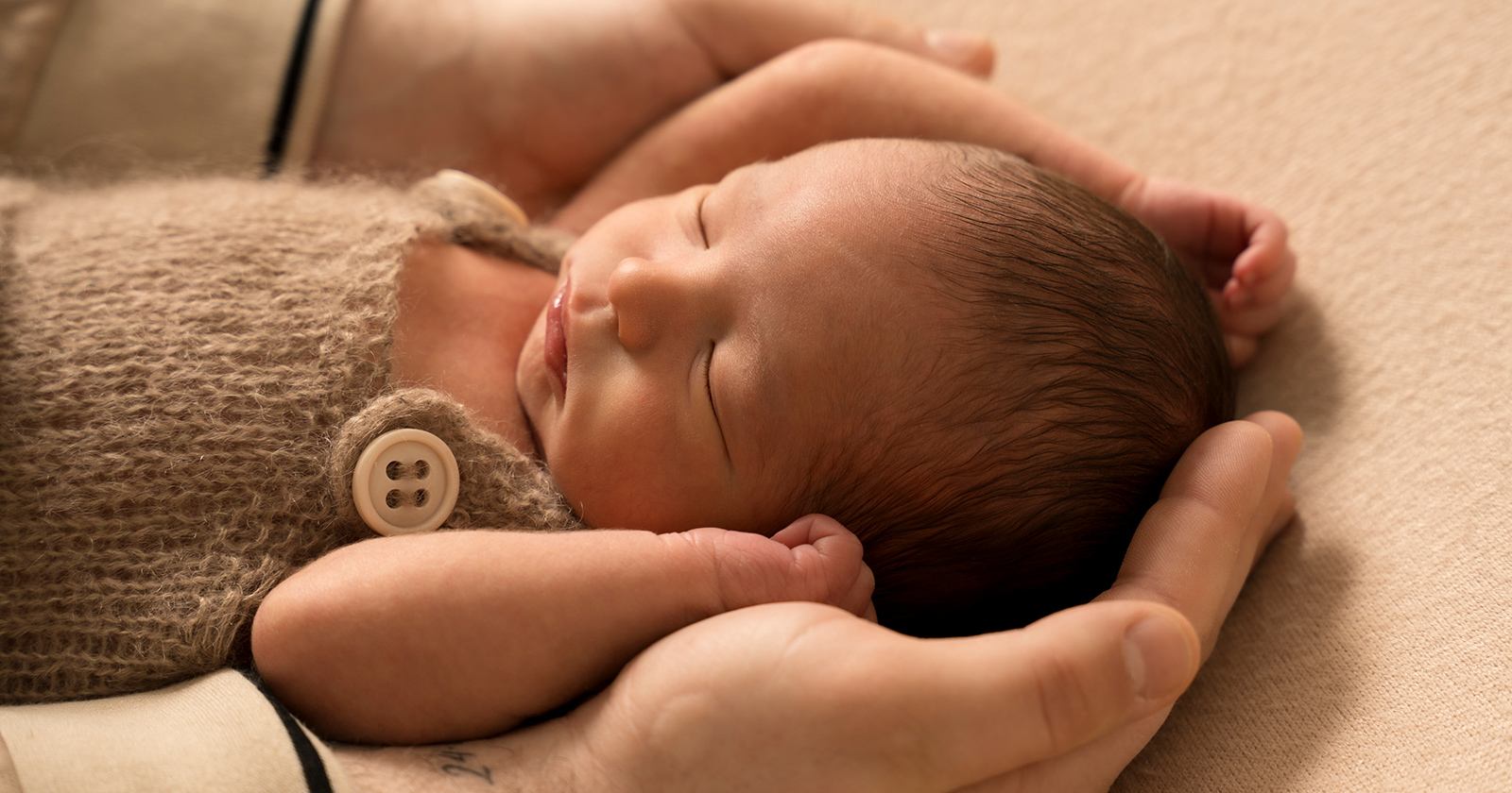 Neugeborenes in den Händen eines Mannes | Credit: Mavie Med Privatkliniken/Artige Babys
