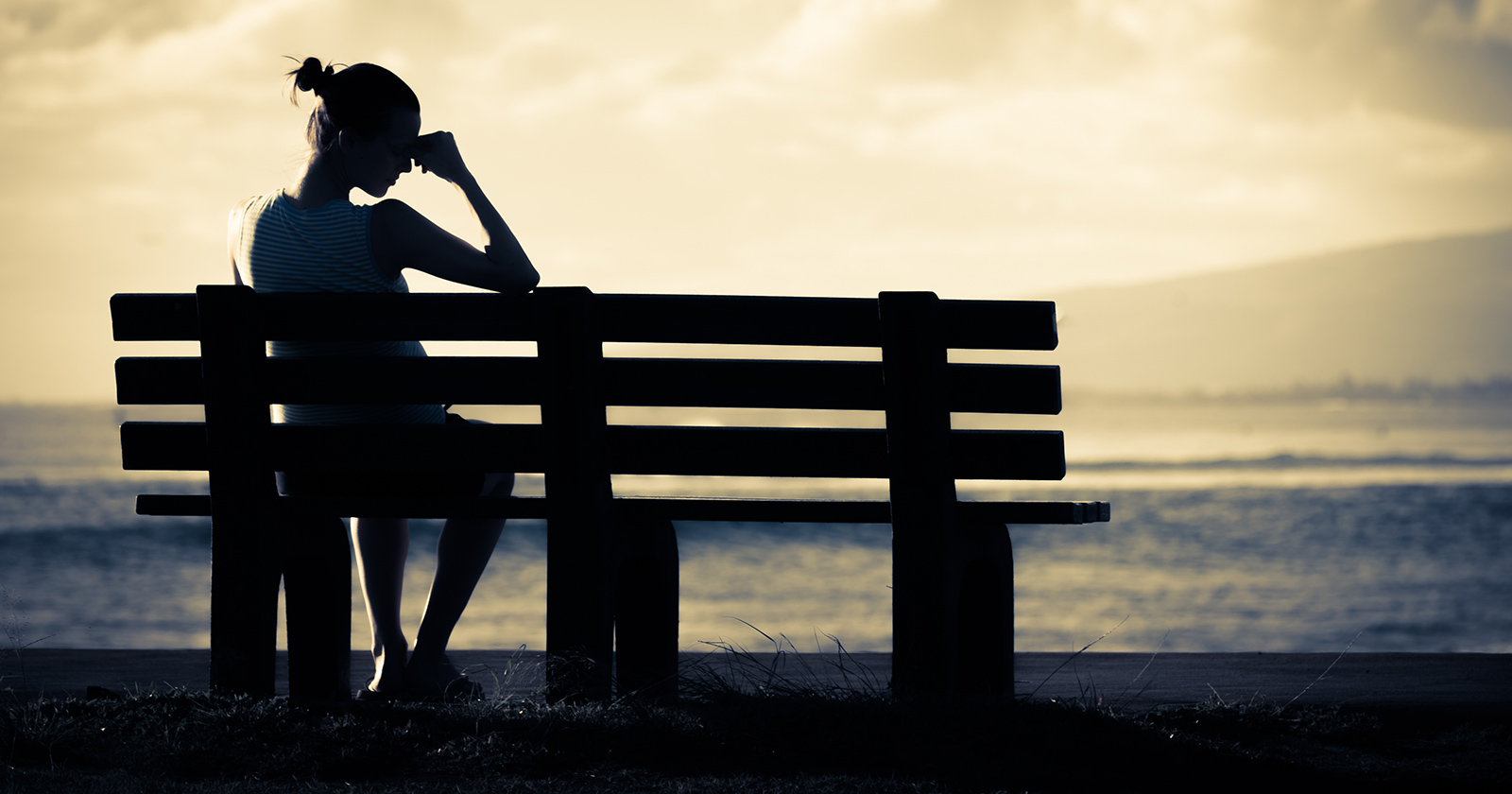 Junge traurige Frau auf der Bank | Credit: iStock.com/kieferpix