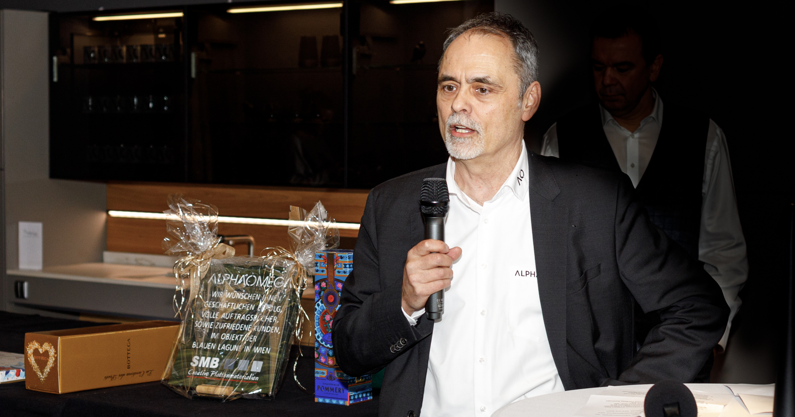 Alphaomega-GF hält ein Mikrofon