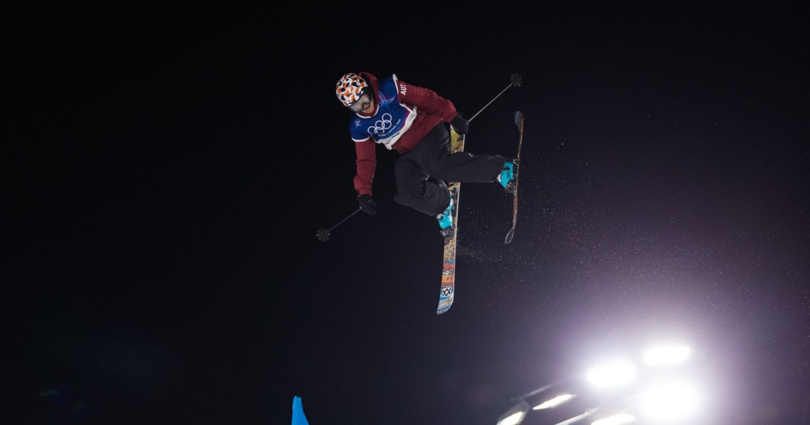 Freeskierin Lara Wolf führt bei Nacht einen Big-Air-Sprung mit Skiern und Stöcken aus, beleuchtet von Scheinwerfern im Livigno Snow Park – Olympische Winterspiele 2026 Ergebnisse im Freestyle-Skiing Big Air