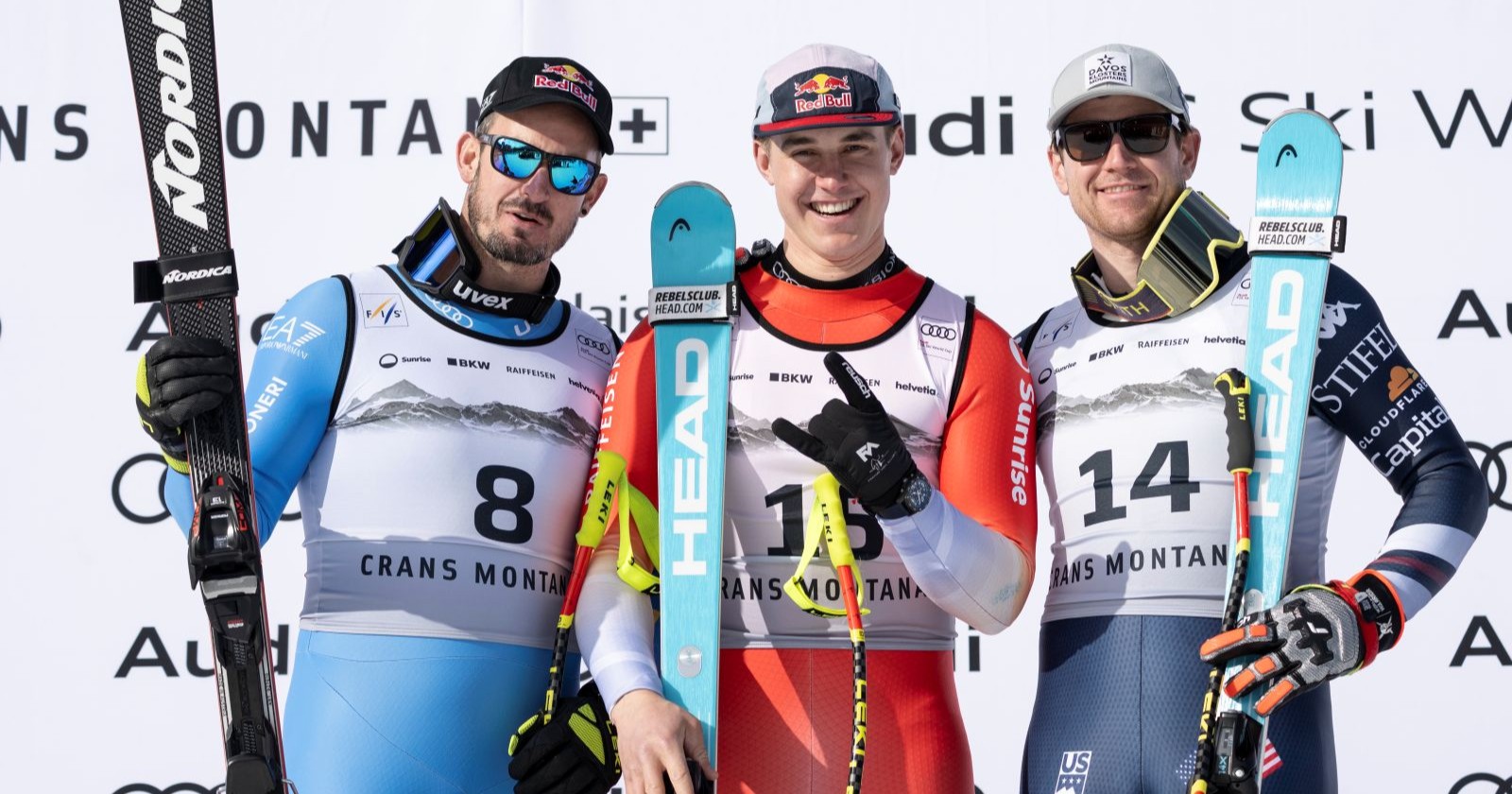 Drei Skirennläufer auf einem Podest