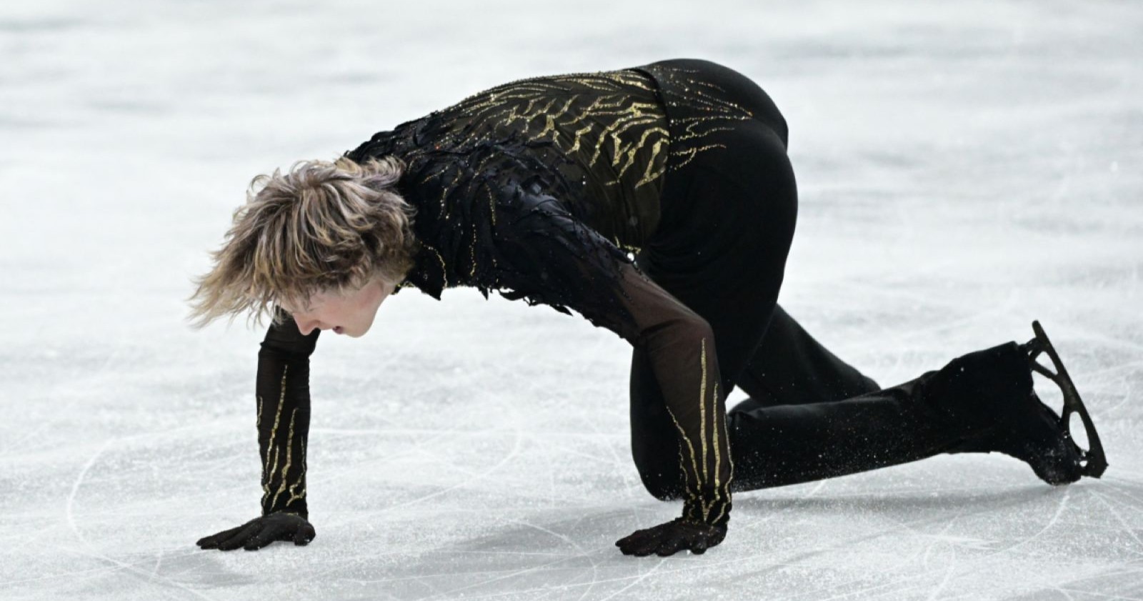 Eiskunstläufer Ilia Malinin kniet nach einem Sturz während seiner Kür auf dem Eis bei den Olympischen Winterspielen in Mailand.