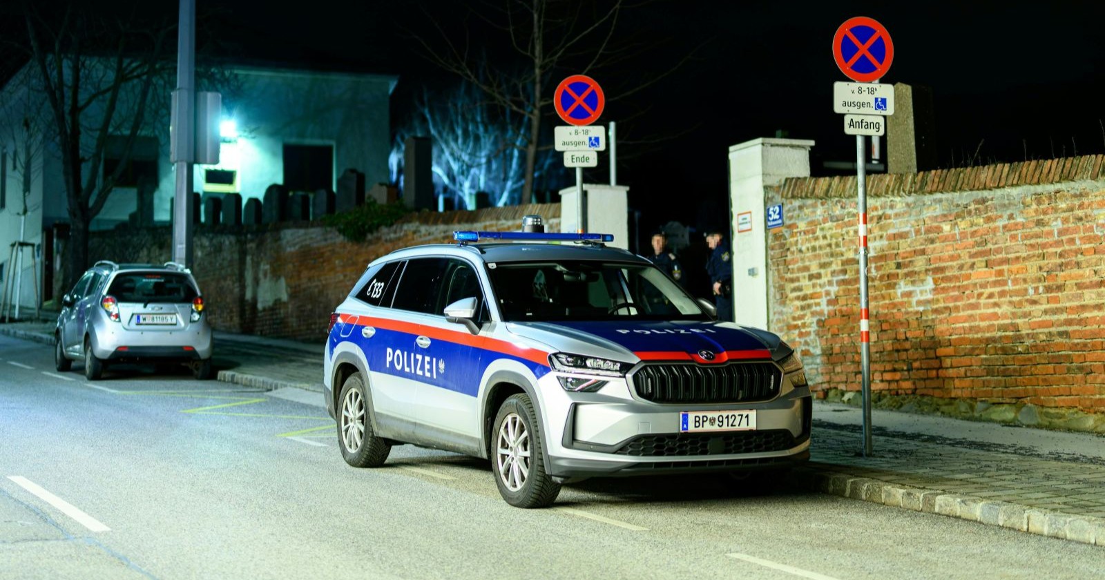 Eingangsbereich des Friedhofs Baumgarten in Wien mit Wagen der Polizei nach einem Gewaltverbrechen.