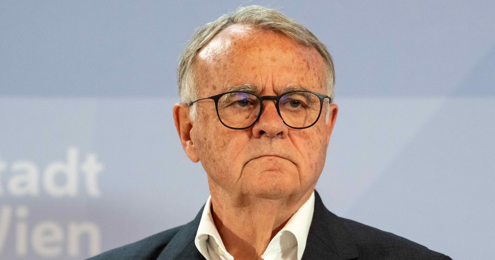 Hans Niessl steht vor einem blauen Hintergrund, trägt Brille und dunkles Sakko – der ehemalige Landeshauptmann des Burgenlandes erwägt eine Kandidatur für die Bundespräsidentenwahl 2028.