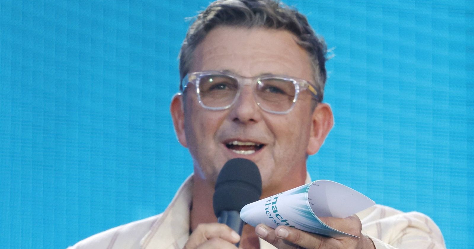 Hans Sigl mit Mikrofon bei einem TV-Auftritt/ Hans Sigl wird im Rahmen des ESC-Vorentscheids vor dem ESC 2026 in Wien moderieren