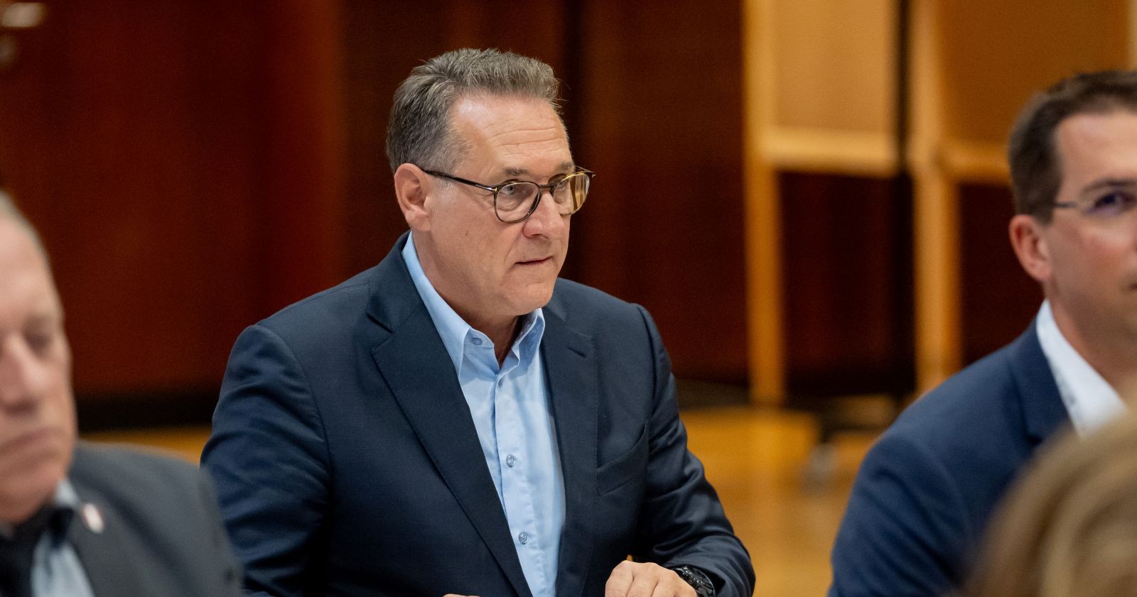 Heinz-Christian Strache sitzt in einem Sitzungssaal und trägt Anzug und Brille. Der Ex-Vizekanzler ist in der Causa Casinos angeklagt.