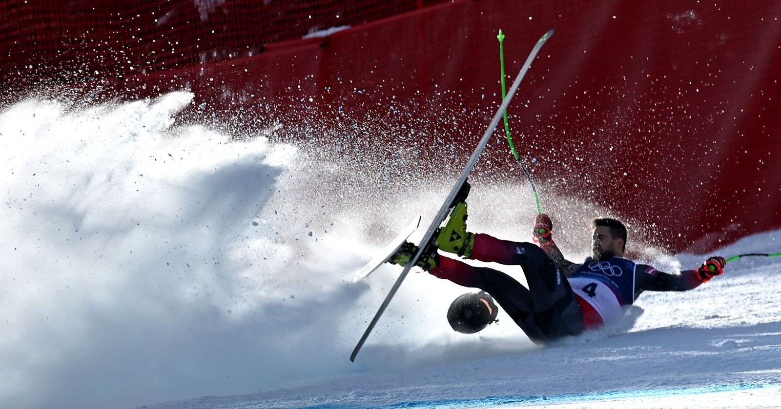 Ein Skirennläufer stürzt bei einem Abfahrtstraining auf der Stelvio-Piste, Schnee spritzt auf, ein Ski löst sich, im Hintergrund ein rotes Sicherheitsnetz – Hemetsberger stürzt schwer, nun gibt es ein Update zu seinen Verletzungen.