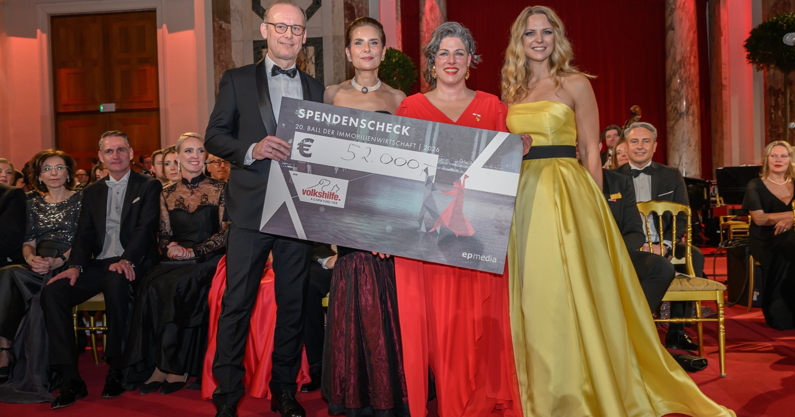 Vier Personen halten den Spendenscheck beim Immobilienball