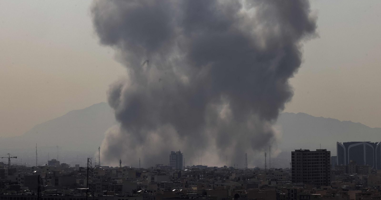 Himmel über Teheran mit Rauchsäulen und Lichtspuren von Abwehrraketen während des Angriffs von Israel und den USA