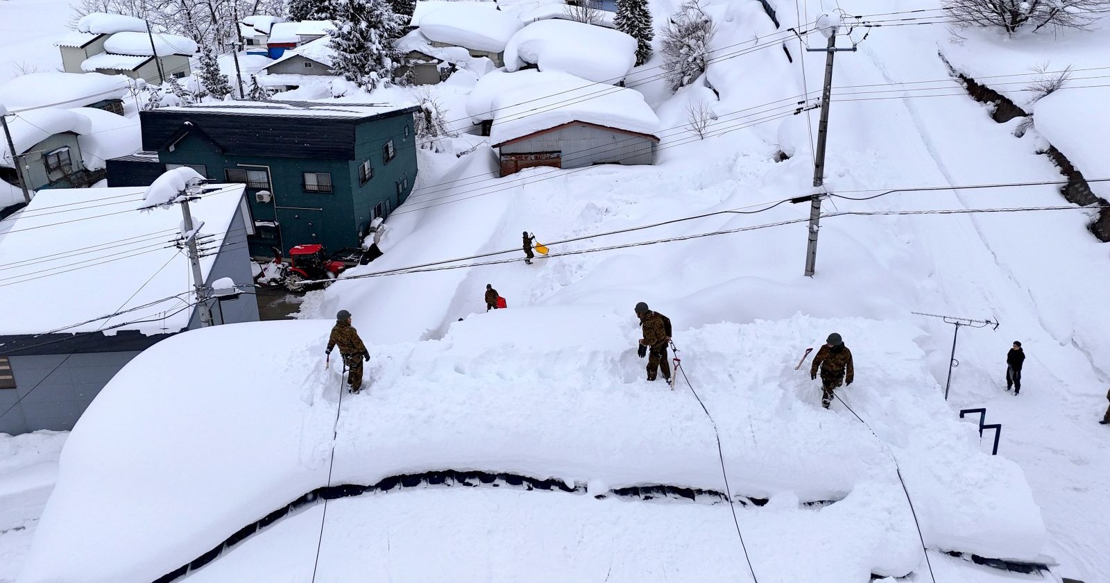 Menschen in Japan schaufeln ihre Häuser bei meterhohen Schneewänden in Aomori frei.