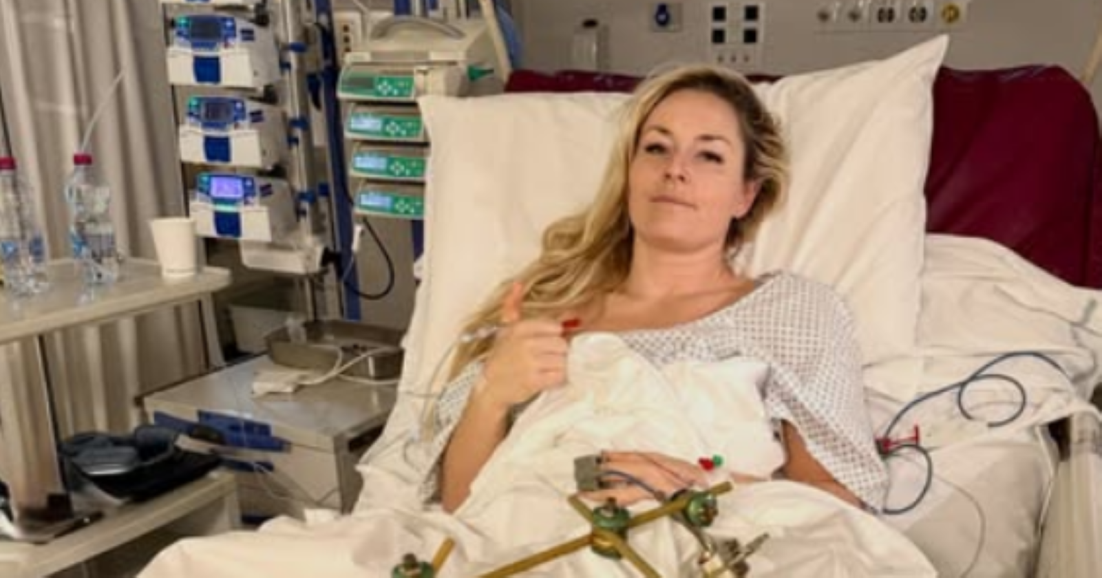 Lindsey Vonn liegt nach mehreren Operationen in einem Krankenhausbett in Treviso und hebt den Daumen, um ihre Genesung und Zuversicht zu zeigen.