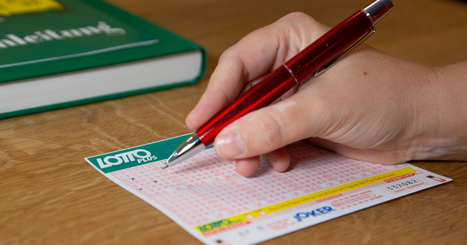 Hand füllt Lotto-6-aus-45-Schein mit rotem Stift aus – Wiener gewinnt bei Lotto-Ziehung 6,1 Millionen Euro im Fünffach-Jackpot.