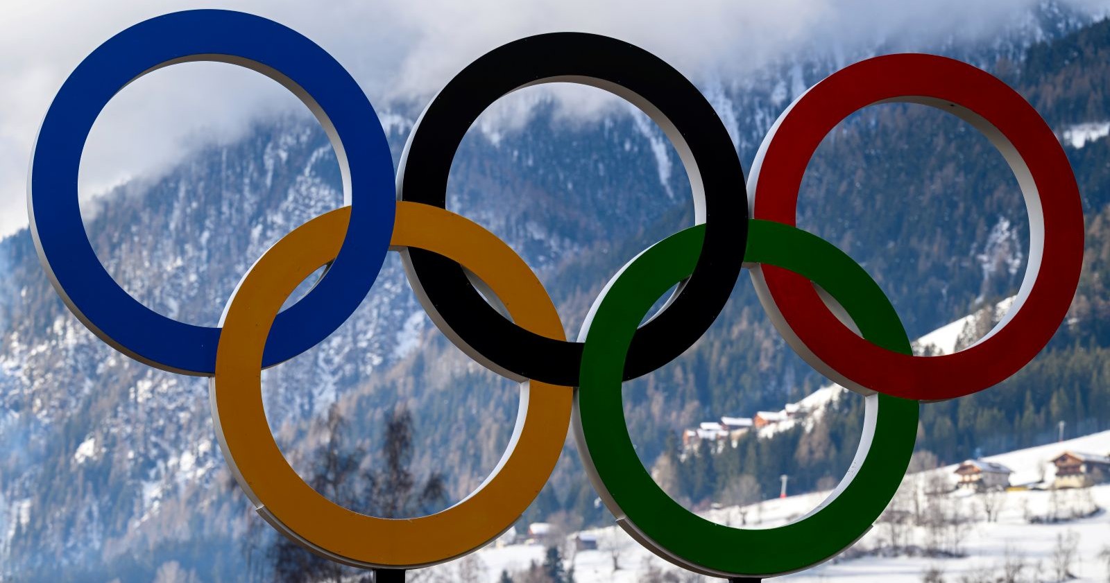 Olympische Ringe vor verschneiten Bergen in Cortina d’Ampezzo, Symbol der Olympischen Winterspiele 2026.